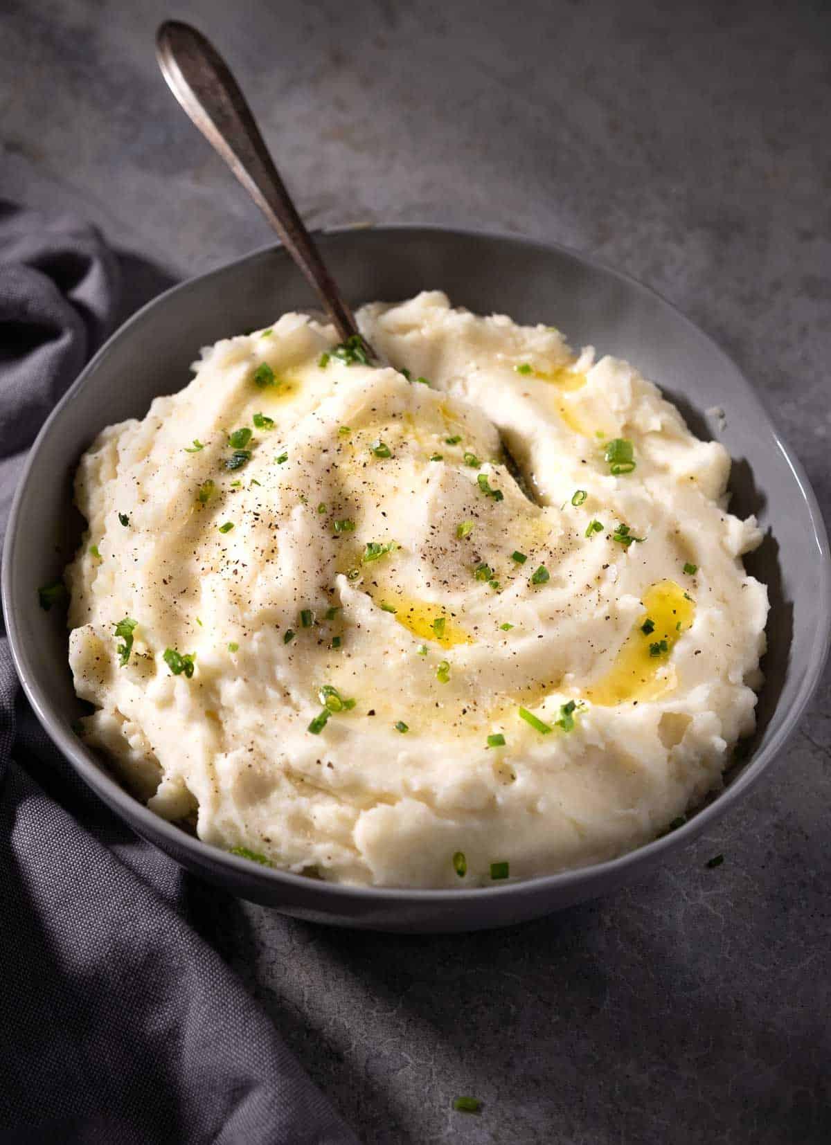 Purè di patate cremoso al rafano 2 Purè di patate al rafano in una ciotola guarnito con burro fuso ed erba cipollina.