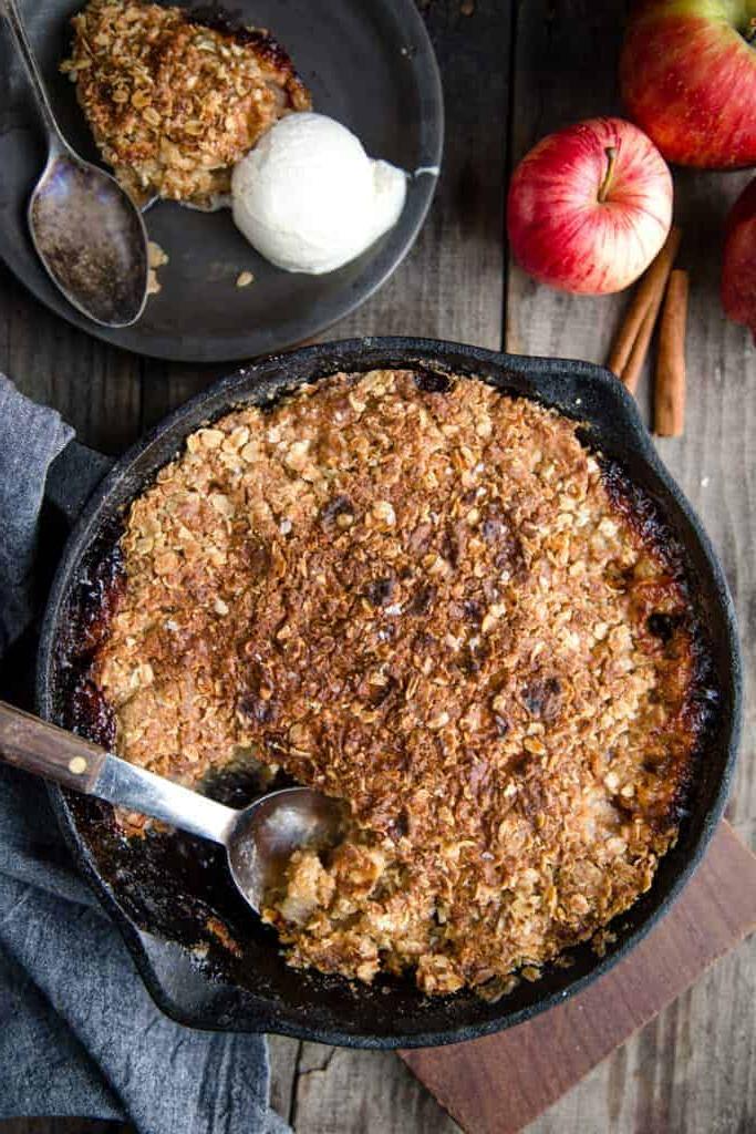**Crumble di Mele Grigliate** 2 Apple Crisp Cotto alla Griglia in una teglia nera con un piatto di apple crisp e gelato a lato