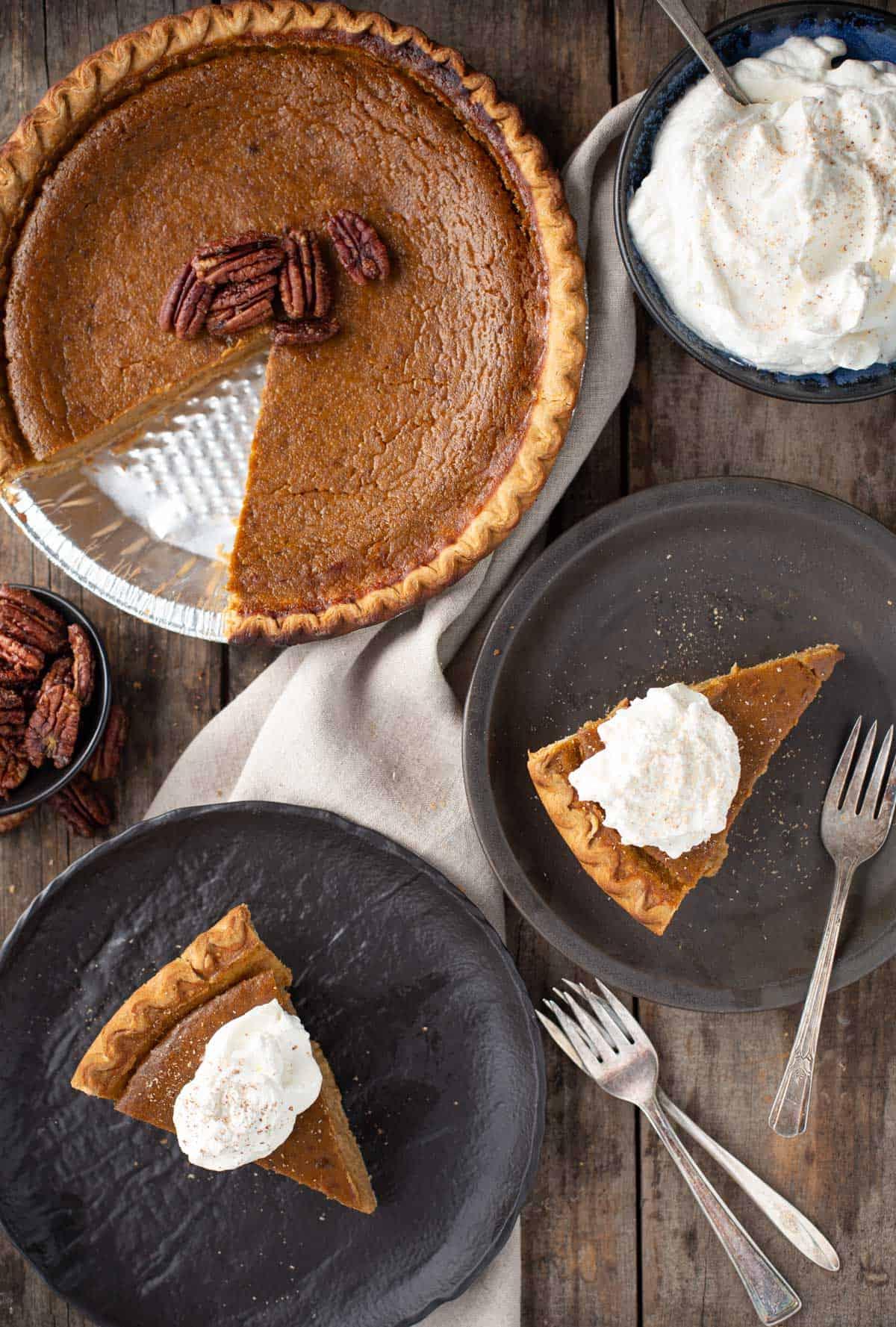 Torta di Zucca Grigliata con Noci Pecan Candite 2 Una torta di zucca grigliata con noci pecan caramellate e due fette su piatti