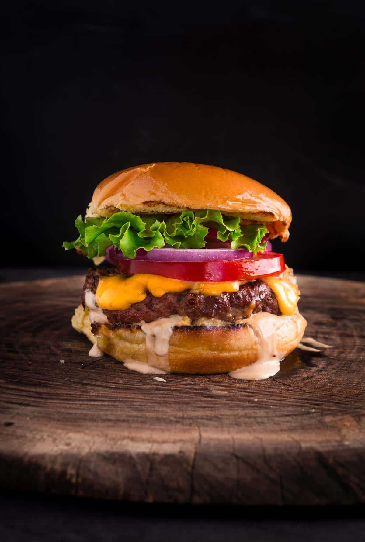 Ricetta dell'Hamburger Affumicato con Formaggio 2 Hamburger affumicato su un tagliere con tutti gli ingredienti.