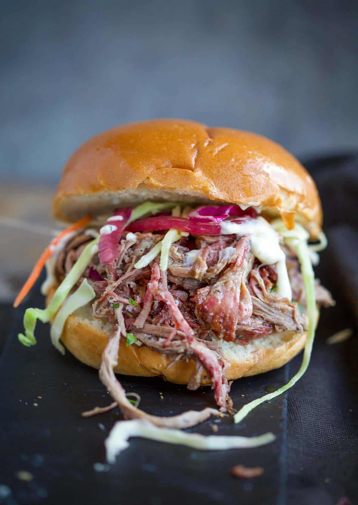 Sliders di Agnello Sfilacciato Affumicato – Il Panino all'Agnello Definitivo 2 Un panino slider di agnello sfilacciato affumicato guarnito con cipolle sott'aceto e coleslaw