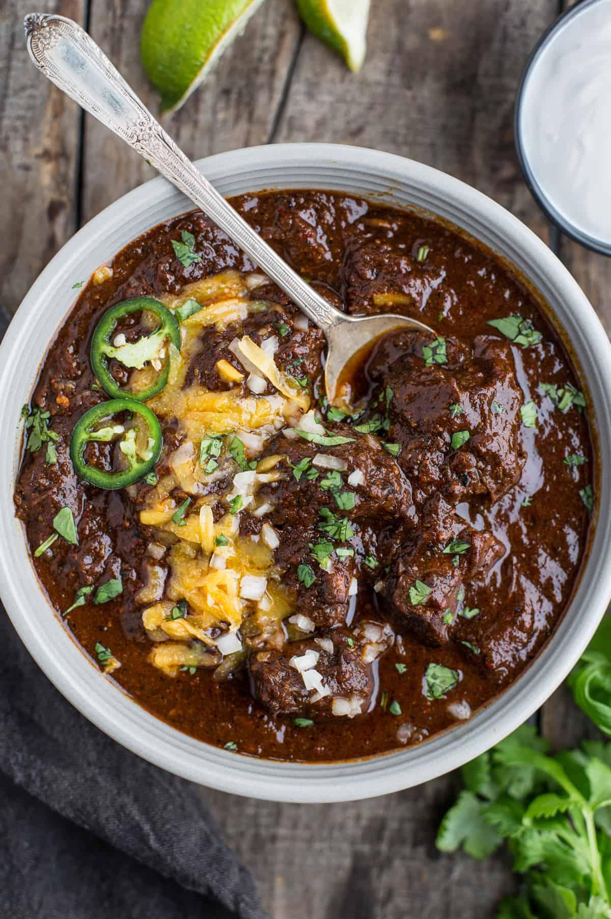 Autentica Ricetta del Chili Texano – (Senza Fagioli) 2 Una ciotola piena di Chili Texano guarnito con formaggio grattugiato, cipolle e jalapeño