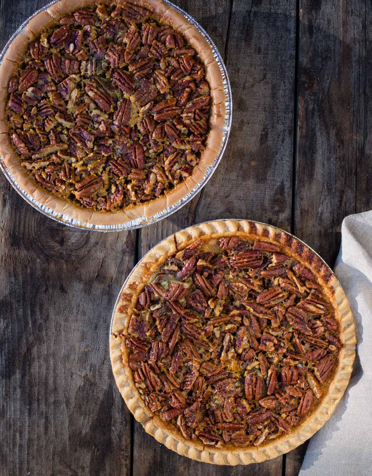 Ricetta Torta Pecan Grigliata con Sciroppo d'Acero e Bourbon 2 Due torte di noci pecan su un tagliere di legno