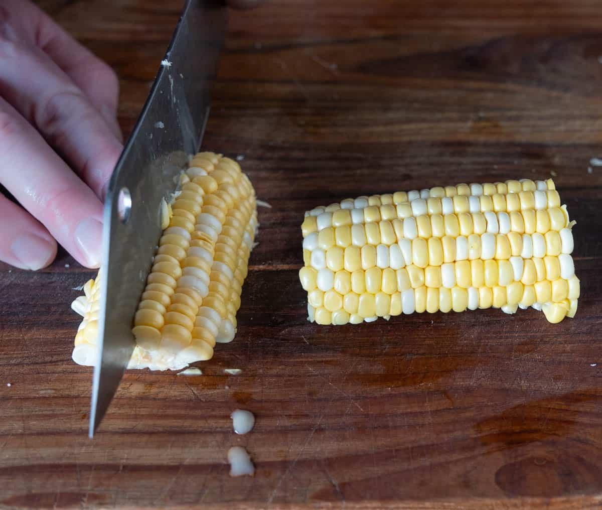Ricetta Facile di Costine di Mais 11 Tagliare a quarti le metà di mais su un tagliere.