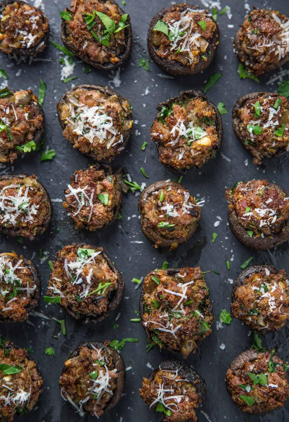 Un piatto da portata di funghi ripieni affumicati e salsiccia.