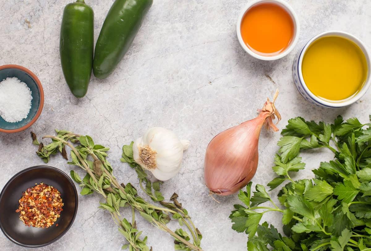 Salsa Chimichurri al Jalapeño – Condimento Perfetto per Bistecca 3 Ingredienti per il chimichurri al jalapeño disposti su un piano di marmo