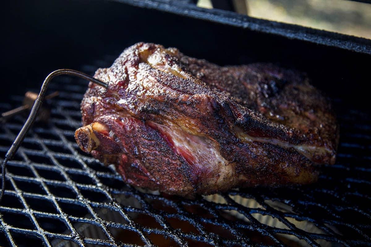 Sliders di Agnello Sfilacciato Affumicato – Il Panino all'Agnello Definitivo 3 Una spalla di agnello con osso in cottura su un affumicatore