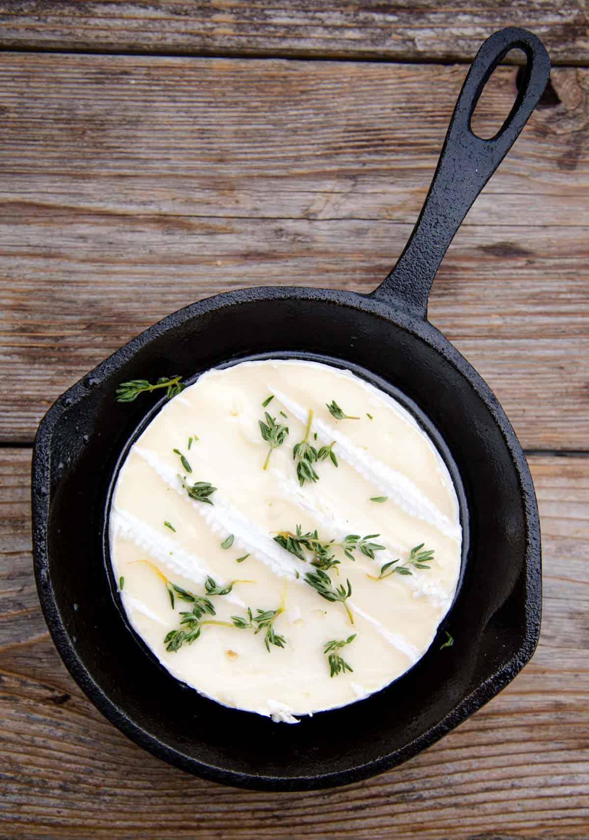 **Brie al Forno con Vino alla Griglia** 3 Formaggio Brie in una padella di ghisa pronto per essere grigliato
