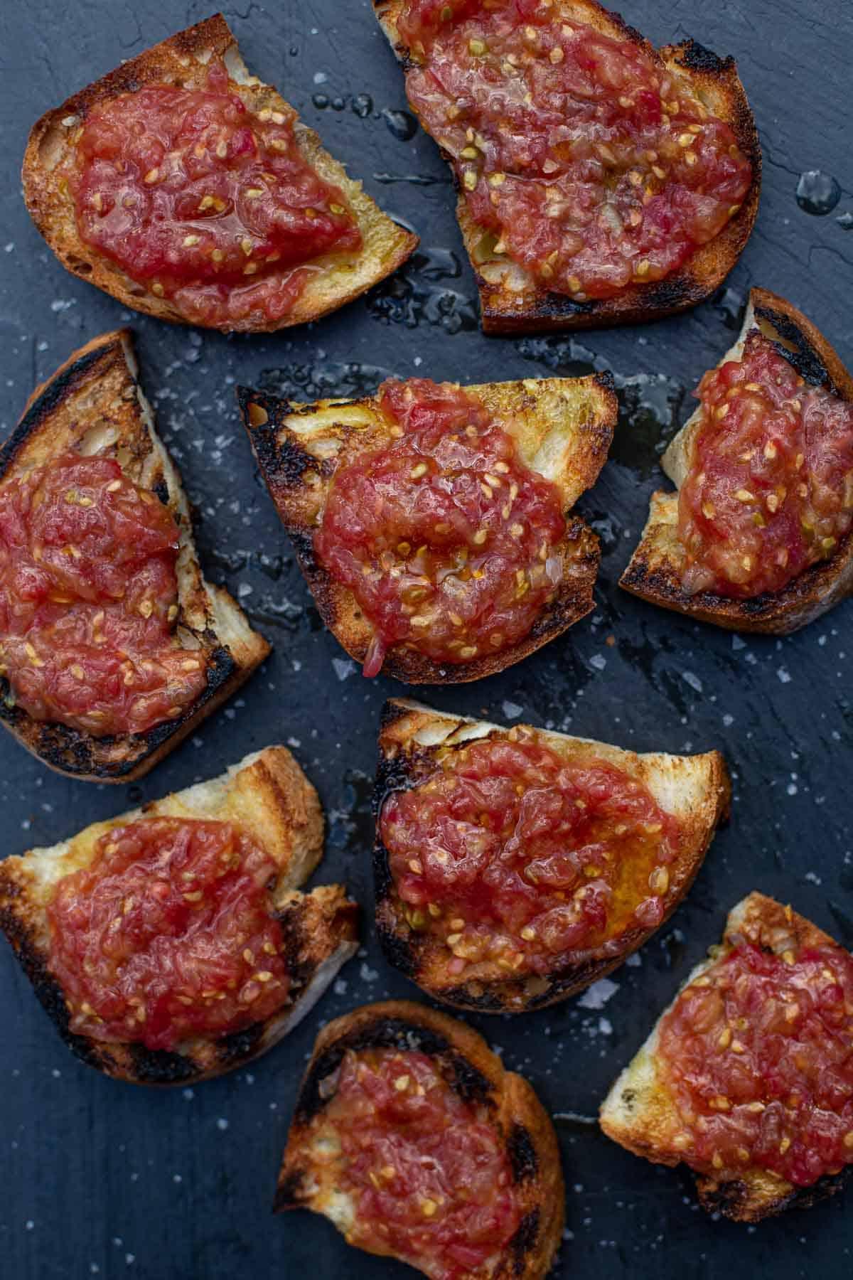 Bruschetta al Pomodoro 3 Pan con Tomate (pane tostato spagnolo al pomodoro) su un piatto da portata
