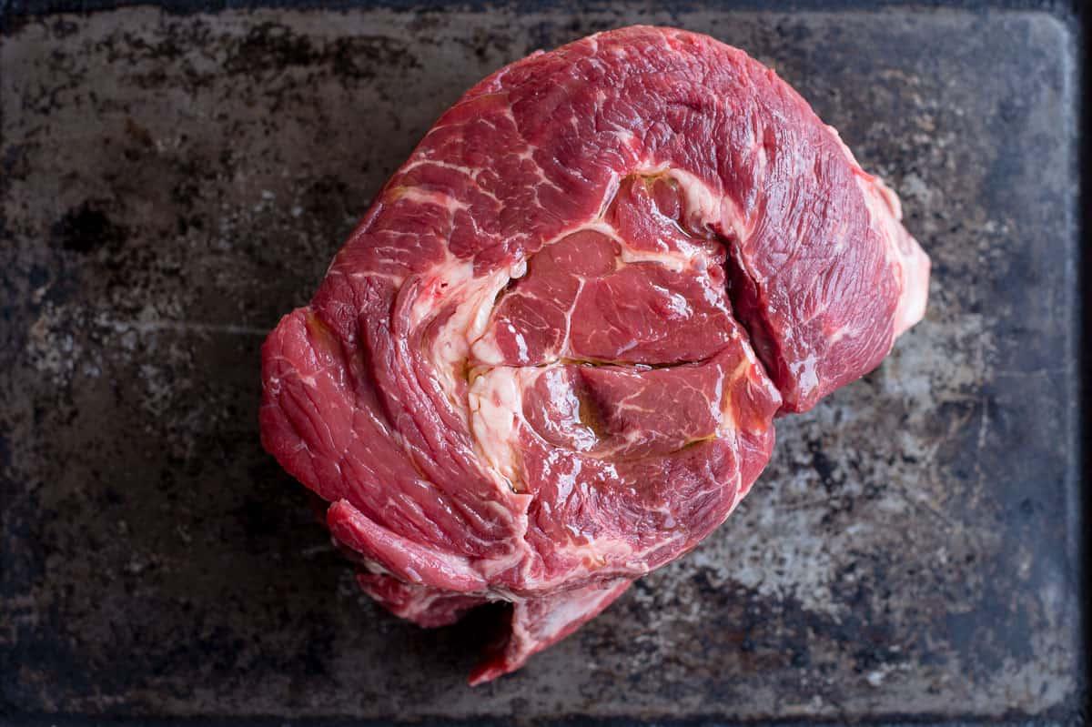 Panini con Manzo Sfilacciato Affumicato Brasato al Vino 3 Un Chuck Roast crudo su una teglia da forno