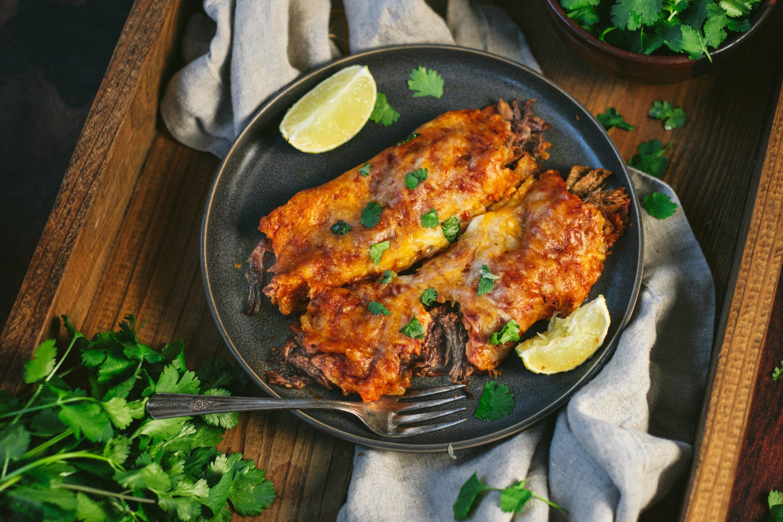 Enchiladas di Maiale Sfilacciato Affumicato 3 Enchiladas di Pulled Pork su un piatto, pronte per essere gustate