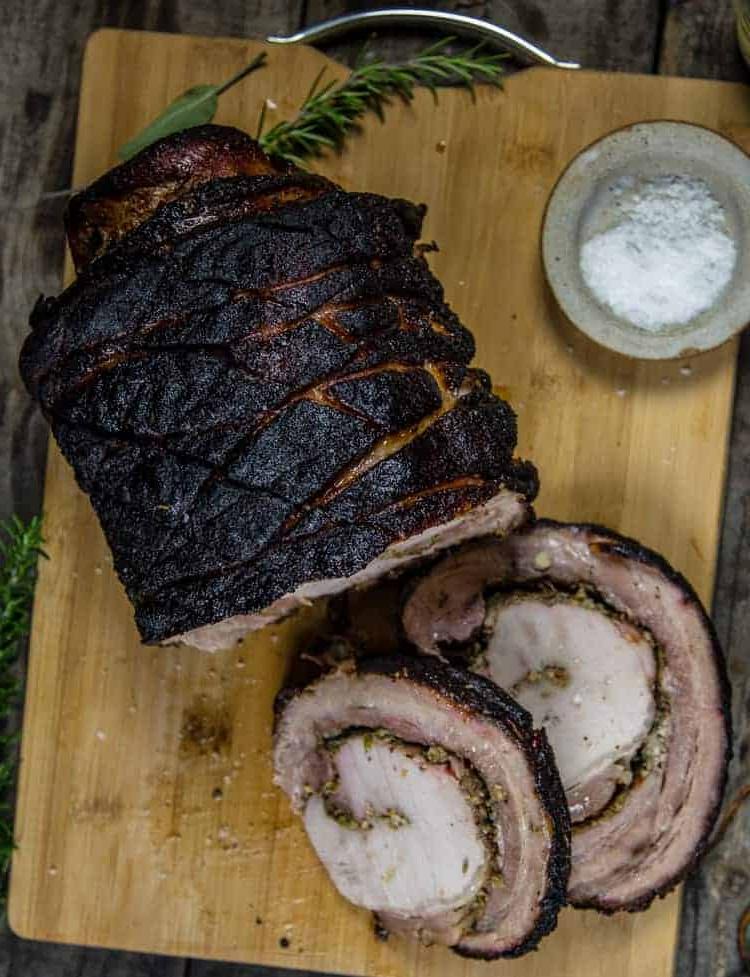 Arrosto di Porchetta Grigliato su un tagliere con fette tagliate che mostrano il ripieno