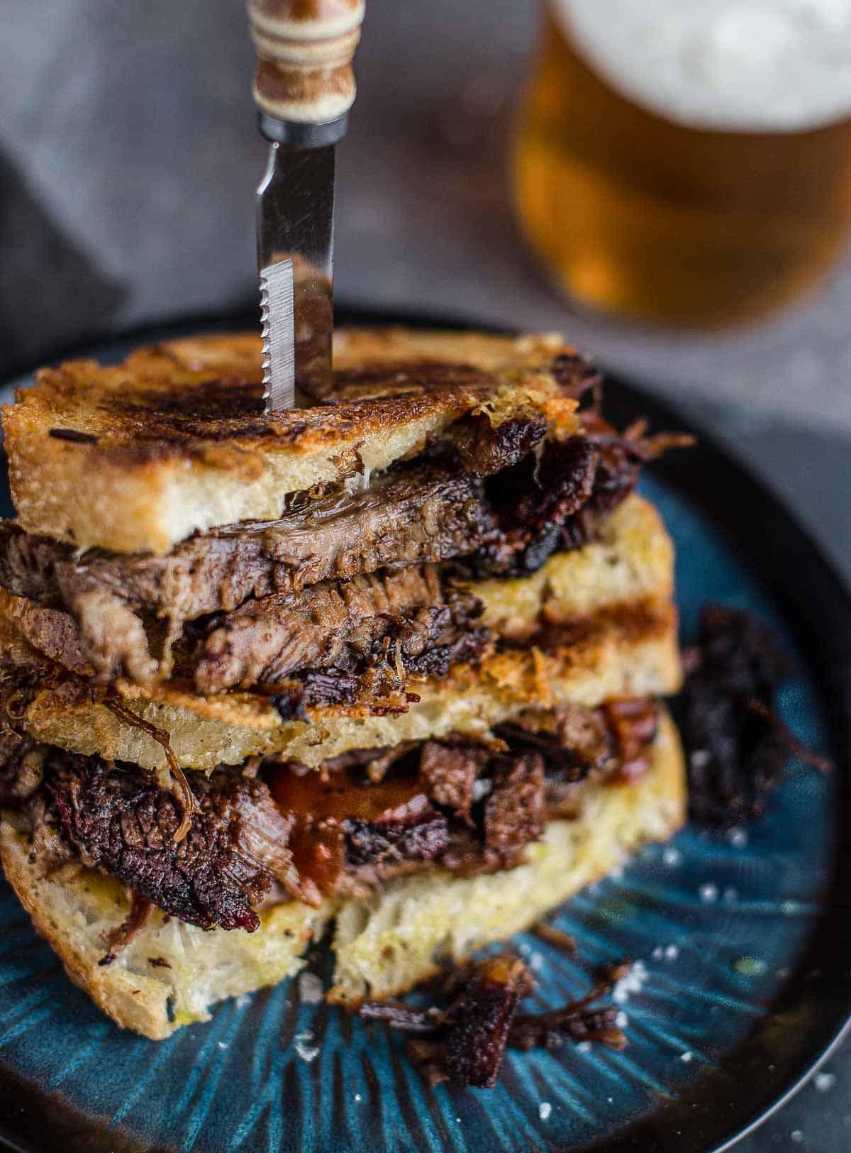 Sandwich con Brisket e Formaggio Fuso 4 Un panino al formaggio grigliato con brisket con un bicchiere di birra