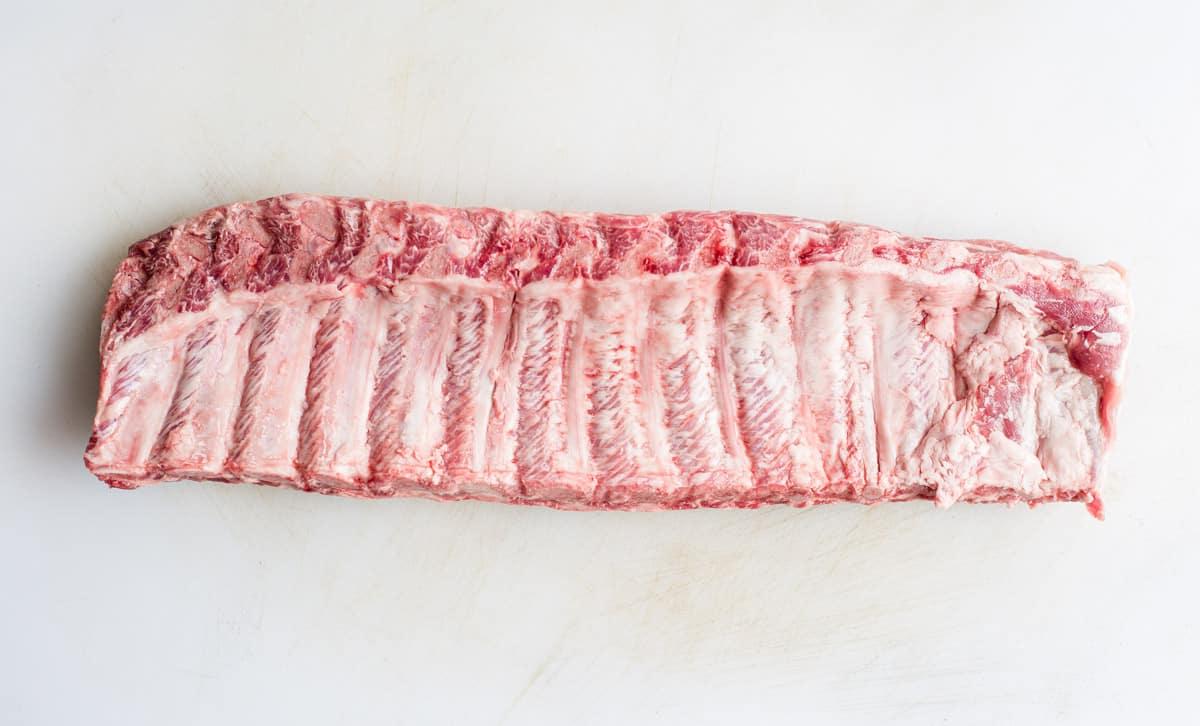 Costine Affumicate al Miele e Senape 4 Baby Back Ribs con il lato delle ossa visibile.