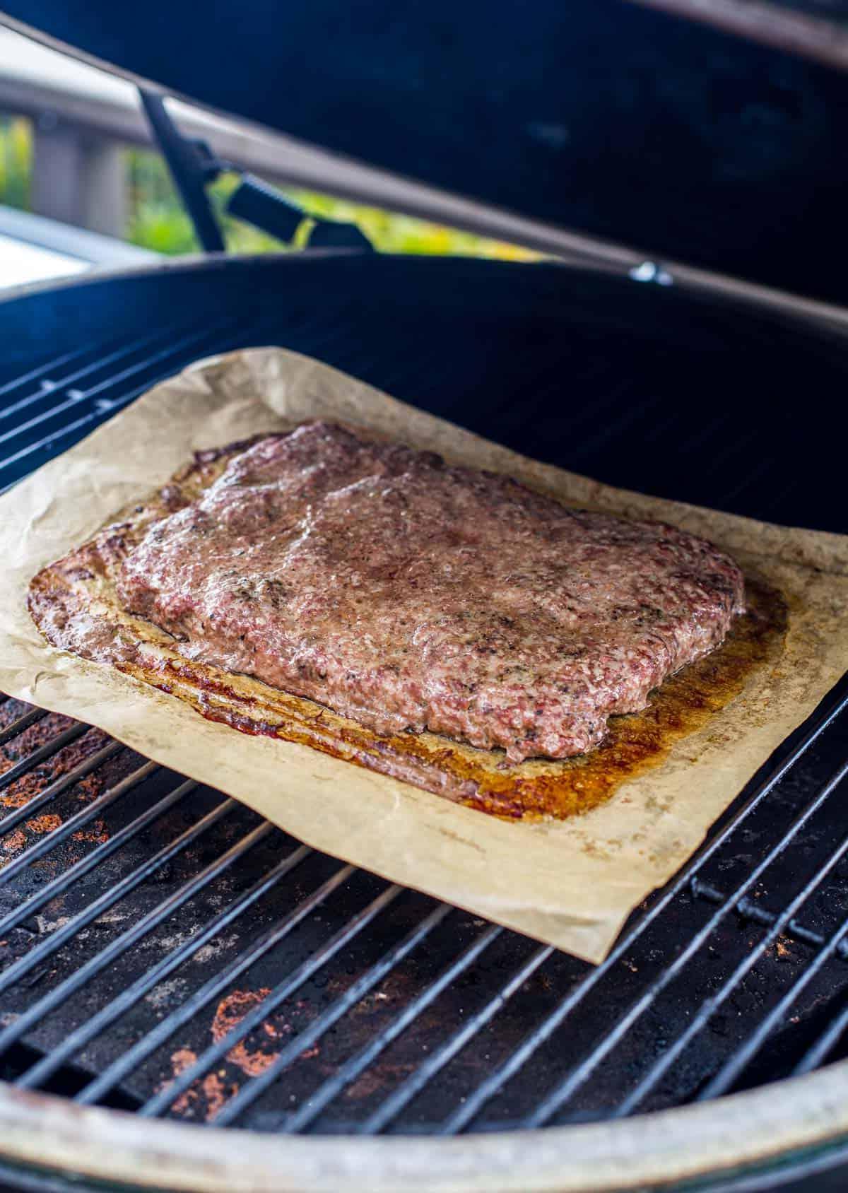 Polpetta di carne macinata per slider su un affumicatore Big Green Egg.