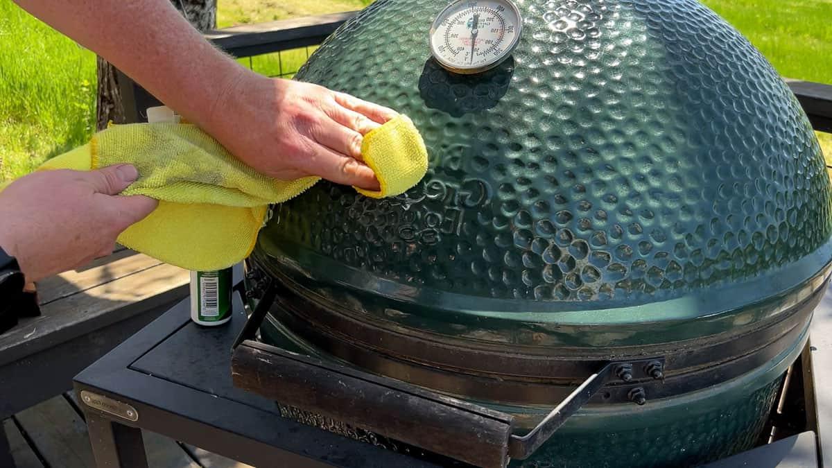 Come Pulire a Fondo e Mantenere il Tuo Big Green Egg o la Tua Griglia Stile Kamado 4 Pulizia delle macchie dall'esterno di un Big Green Egg XL con un panno in microfibra e un detergente non abrasivo.