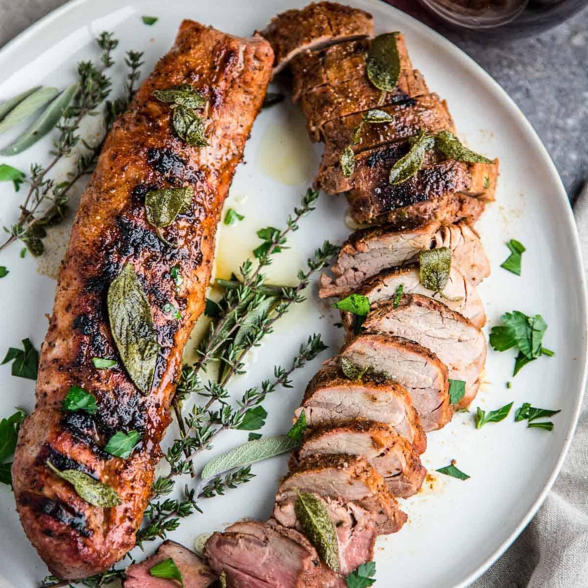 Filetto di Maiale Grigliato su un piatto guarnito con salsa al burro e salvia fritta