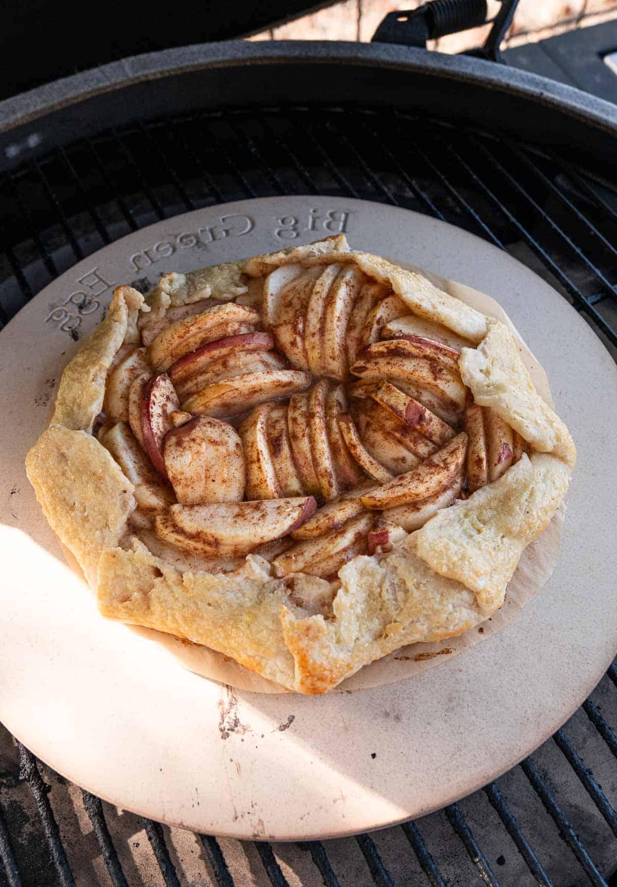 Galette alle Mele Grigliate 5 Galette di mele che cuoce su una griglia Big Green Egg sopra una pietra refrattaria.