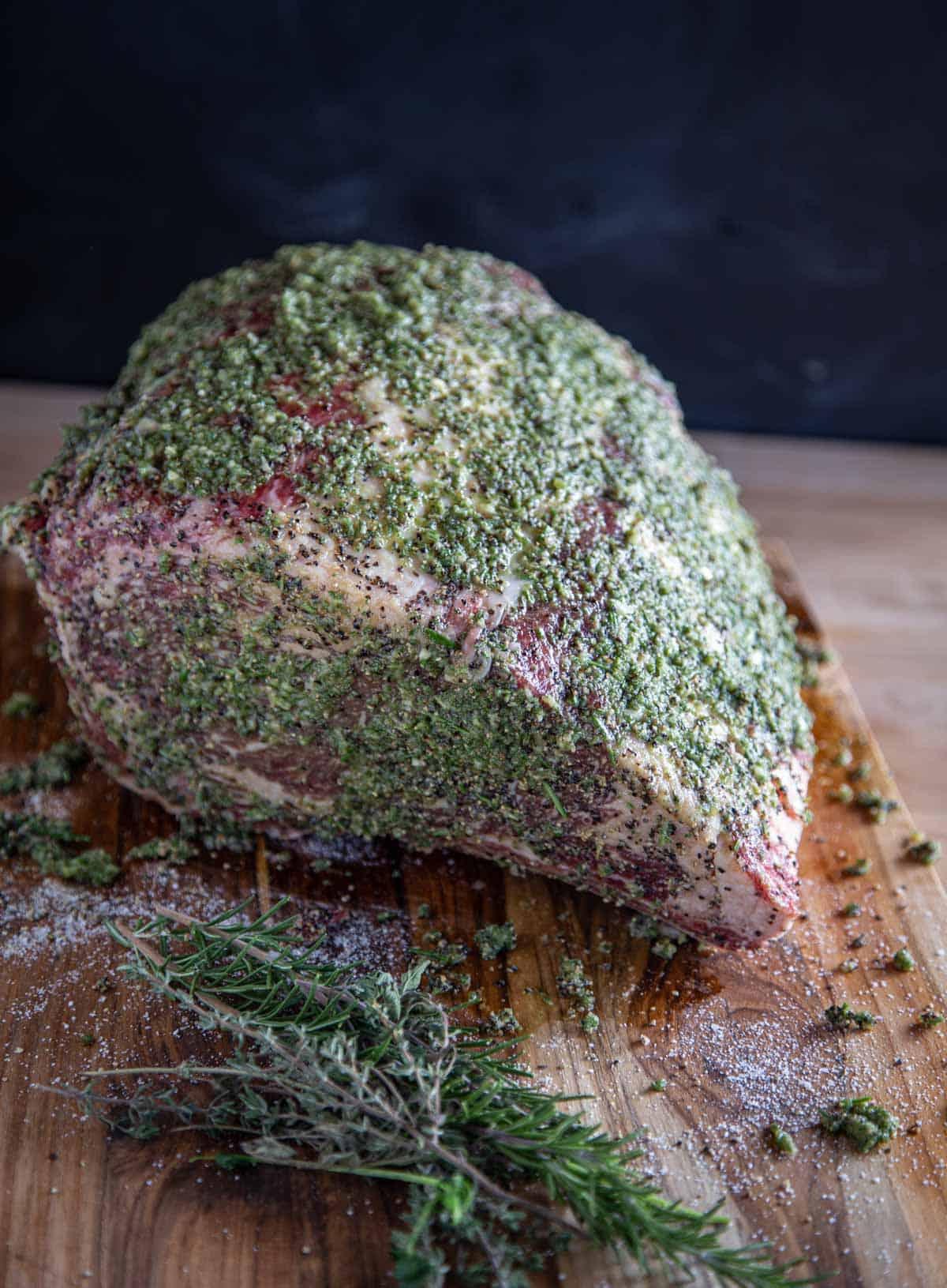 La Migliore Costata di Manzo Affumicata (Ricetta + Video) 5 Arrosto di Costata di Manzo condito con pasta di erbe su un tagliere.