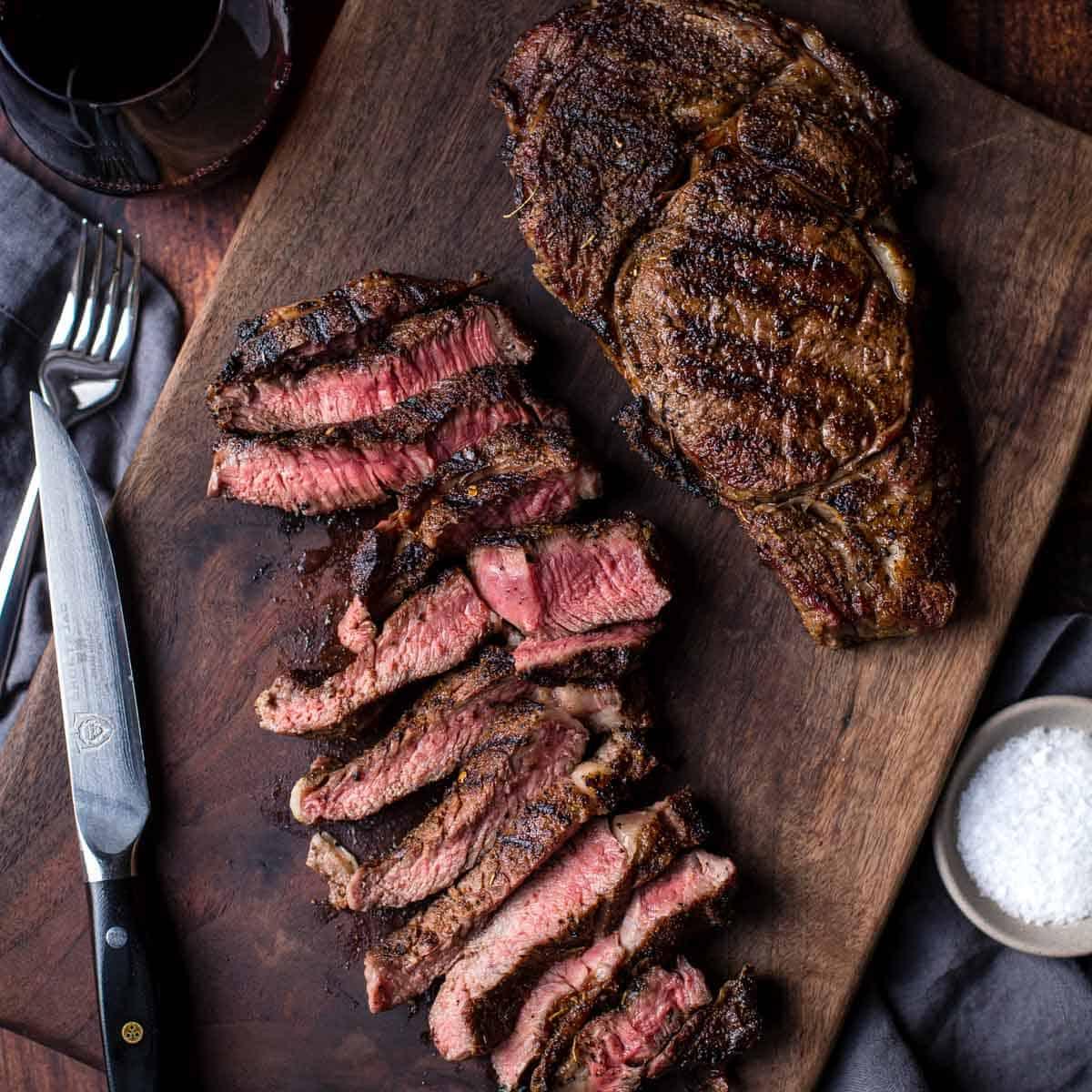 Qual è la Temperatura Perfetta per la Bistecca? 5 Due bistecche ribeye alla griglia su un tagliere