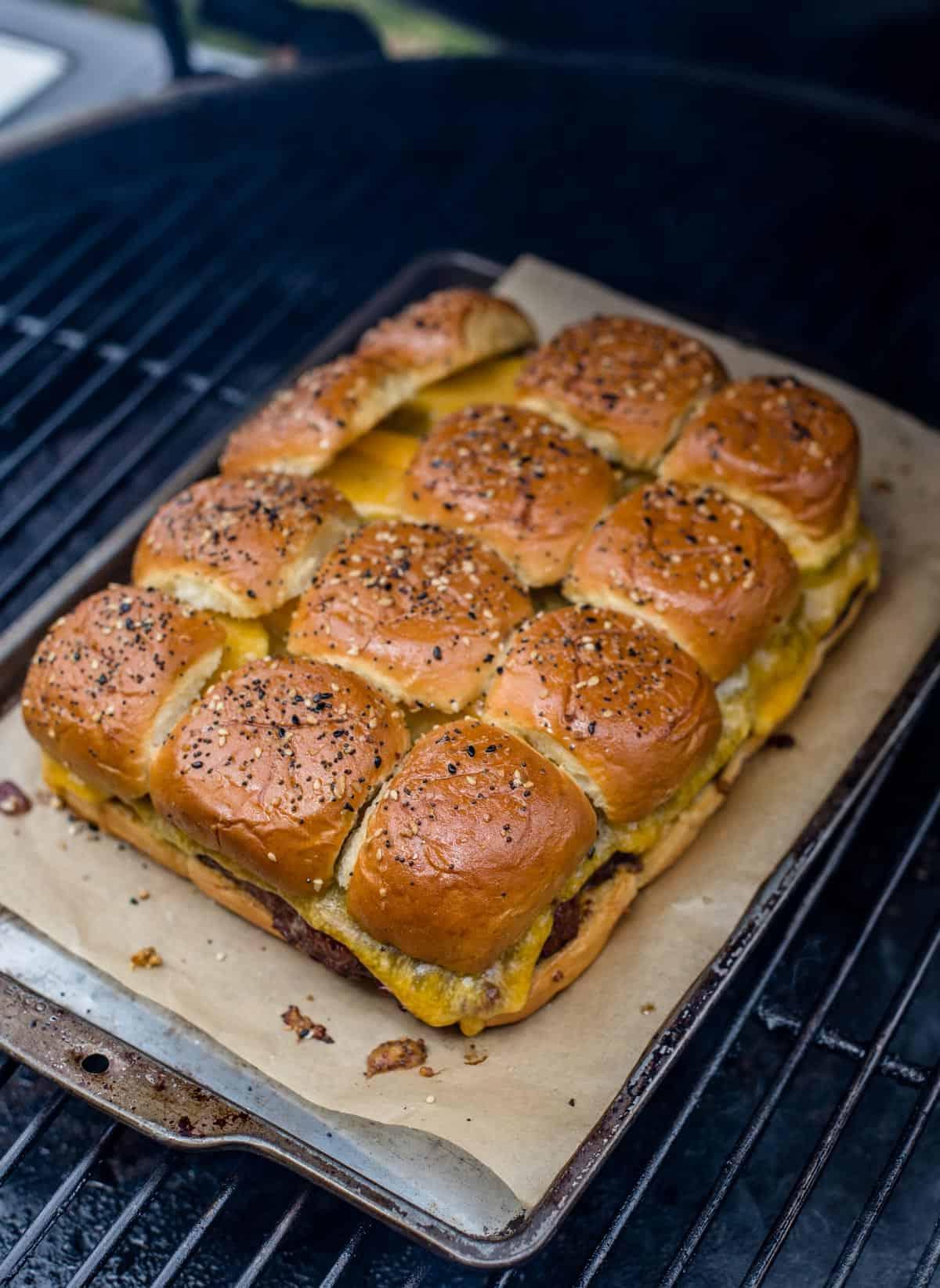 Cottura dei slider di cheeseburger sulla griglia del Big Green Egg.