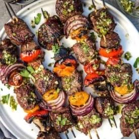 Spiedini di Manzo con Chimichurri al Jalapeño e Prezzemolo 6 Spiedini di Manzo Grigliati su un piatto