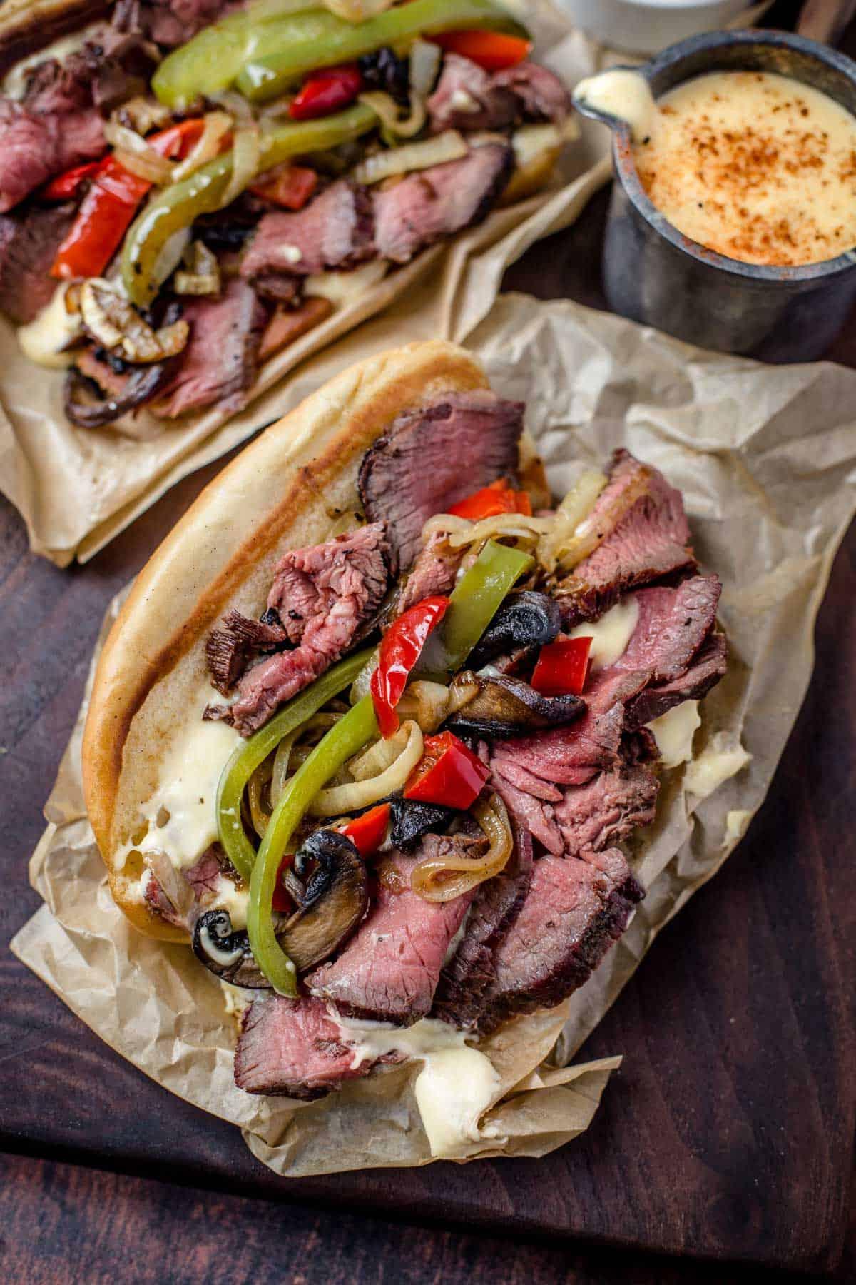 **Panino Grigliato al Cheesesteak** 6 Due panini cheesesteak su un piatto da portata con i condimenti.