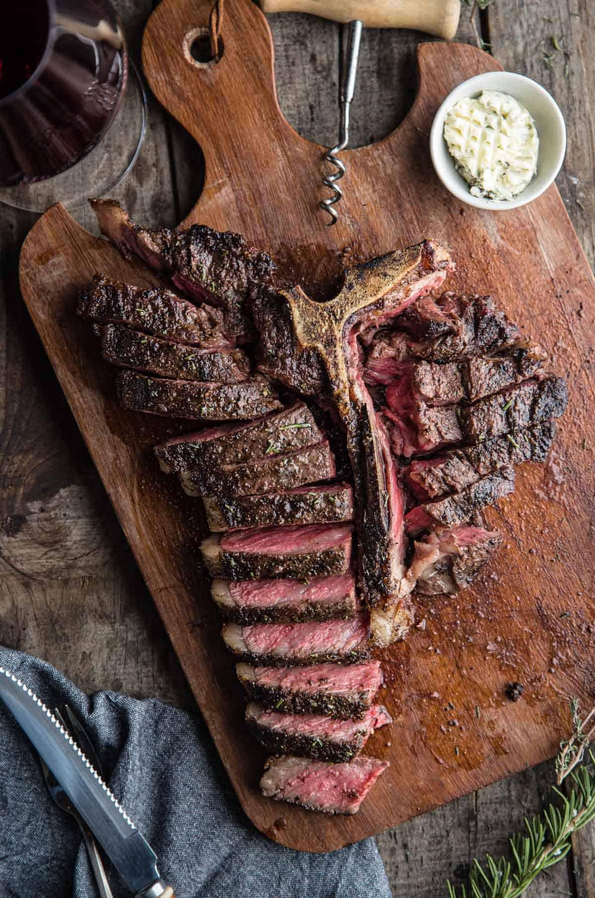 Choice vs Prime – Qual è la qualità migliore per grigliare e affumicare? 6 Una bistecca T-Bone alla griglia affettata e servita con un bicchiere di vino
