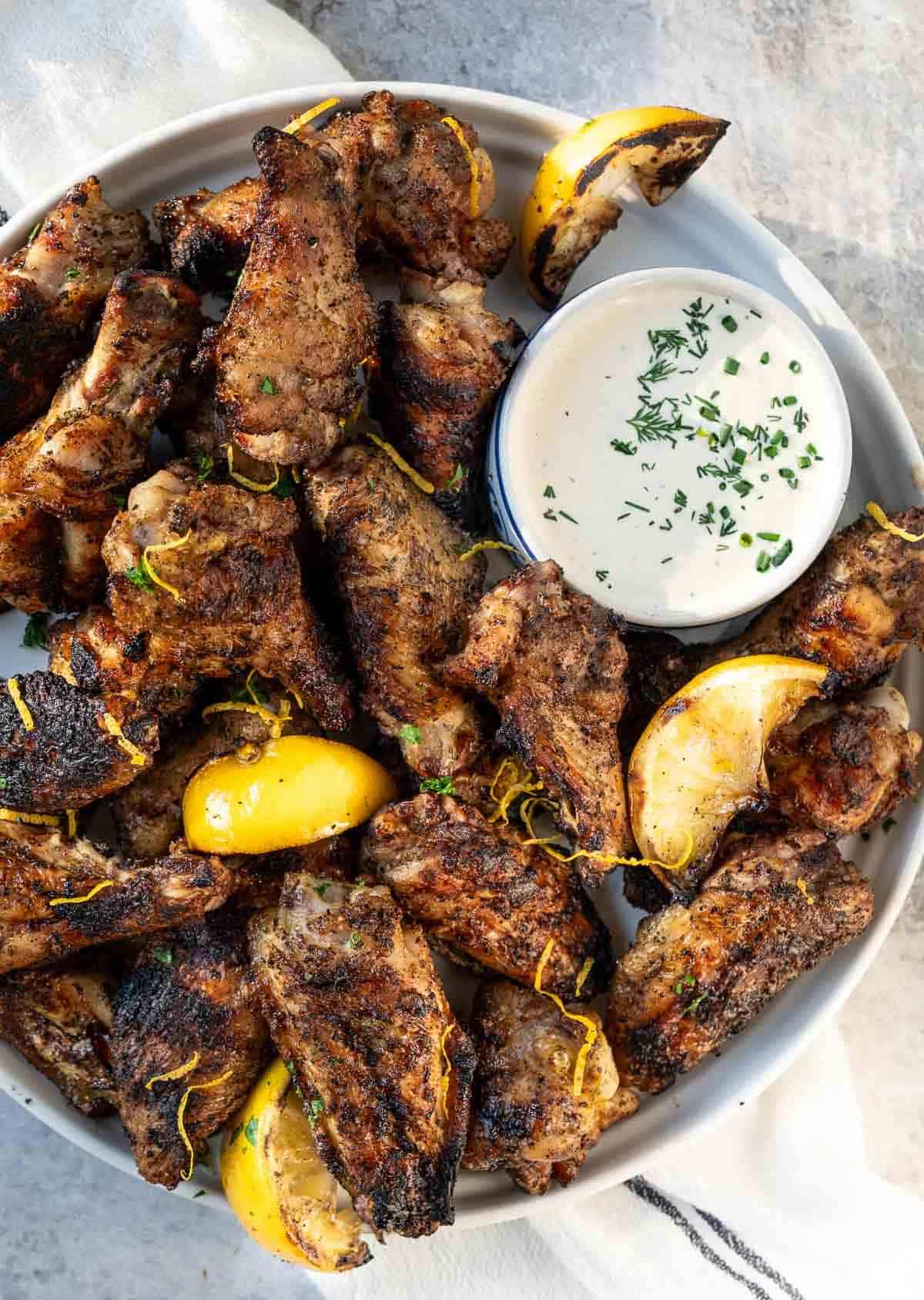 Ali di Pollo al Limone e Pepe su un vassoio bianco con una ciotola di salsa ranch fatta in casa.