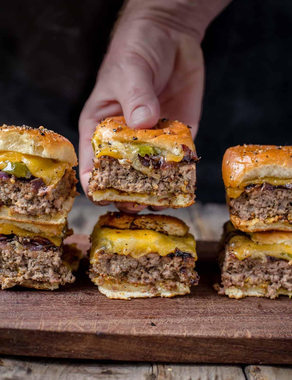 Sei slider di cheeseburger su un tagliere.