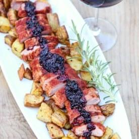 Filetto di Maiale Affumicato con Salsa Affumicata di More al Bourbon 6 Filetto di maiale affumicato con salsa ai lamponi e bourbon affettato su un tagliere