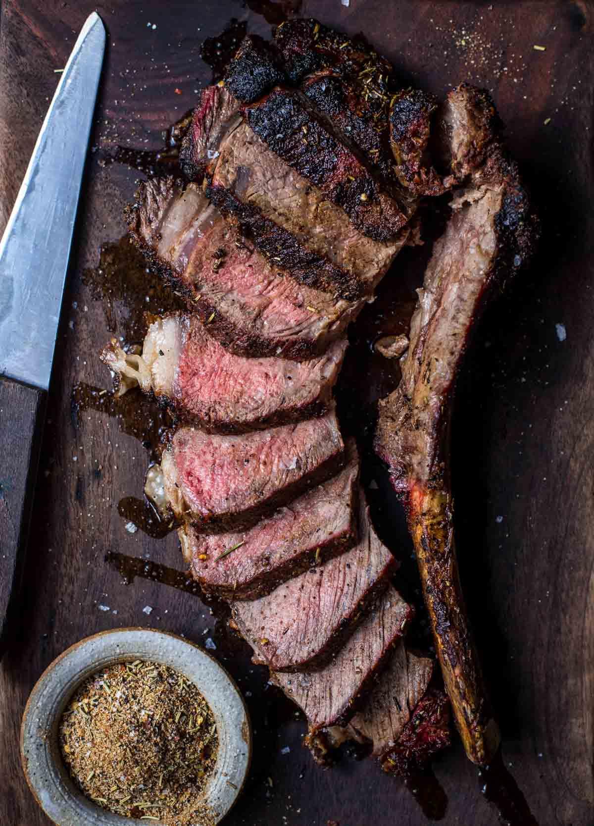 Ricetta della Bistecca Tomahawk Grigliata alla Perfezione 7 Bistecca tomahawk affettata su un tagliere.