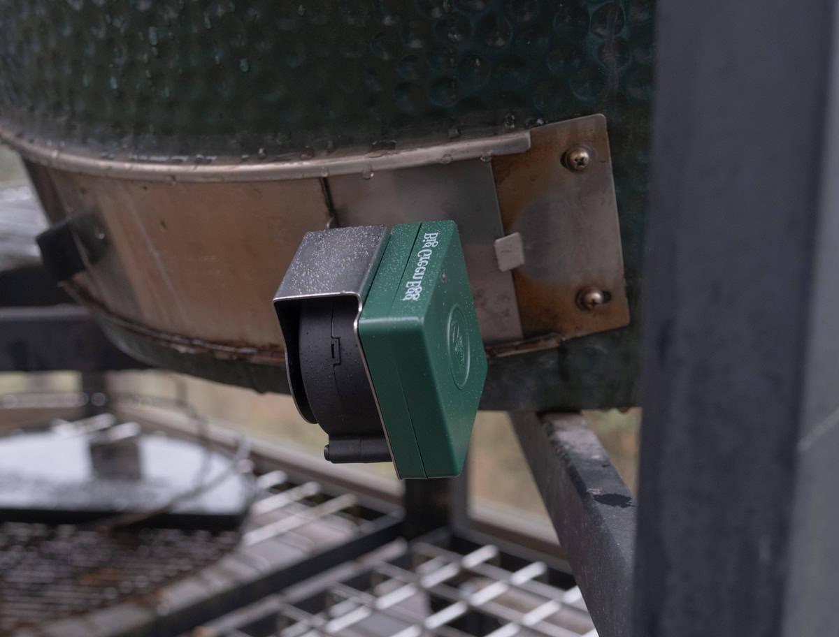 Come Usare il Big Green Egg Egg Genius 8 L'egg genius posizionato sulla piastra di montaggio nella valvola di tiraggio inferiore di un Big Green Egg XL.