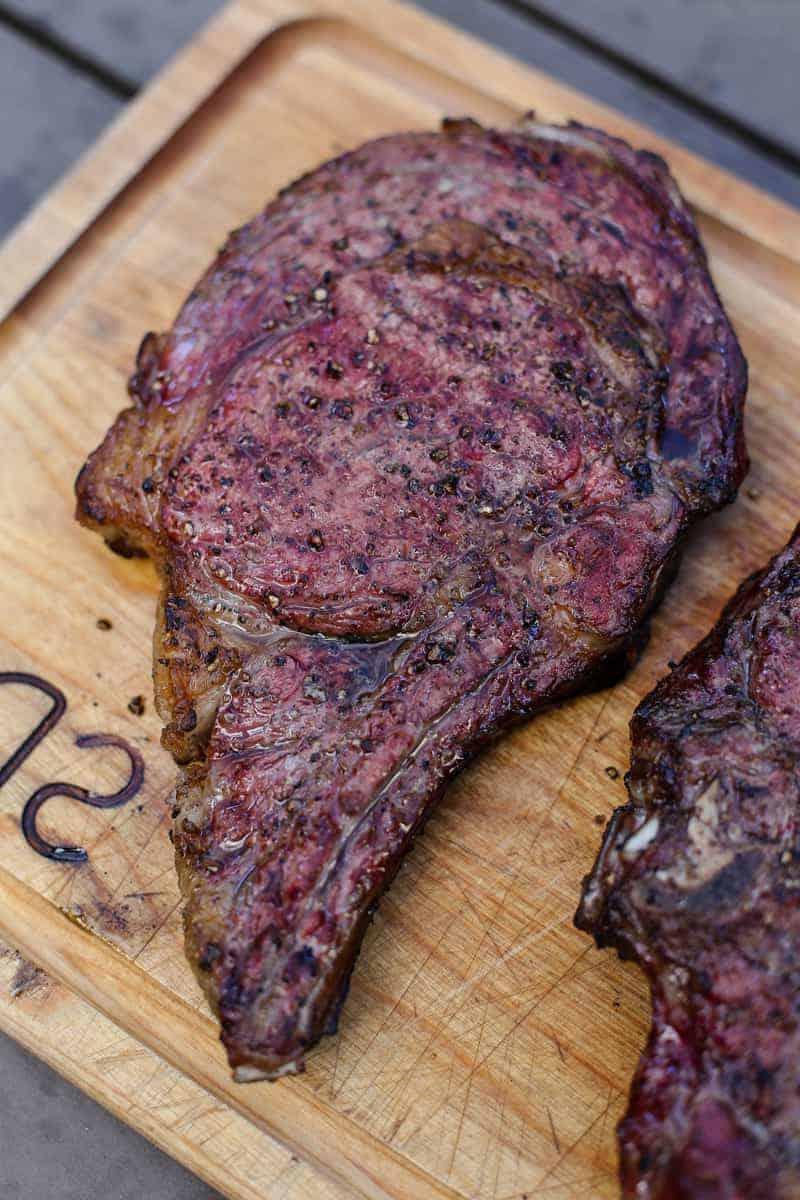 Bistecca Ribeye con Cottura Inversa 8 Bistecca Ribeye affumicata e cotta con metodo inverso che riposa su un tagliere