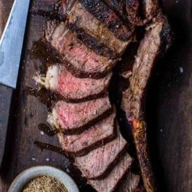 Ricetta della Bistecca Tomahawk Grigliata alla Perfezione 9 Bistecca tomahawk affettata su un tagliere.