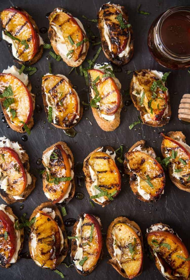 Crostini di Pesche Grigliate con Mascarpone e Miele 2 Crostini di Pesche Grigliate con Mascarpone e Miele su un piatto di ardesia nera.