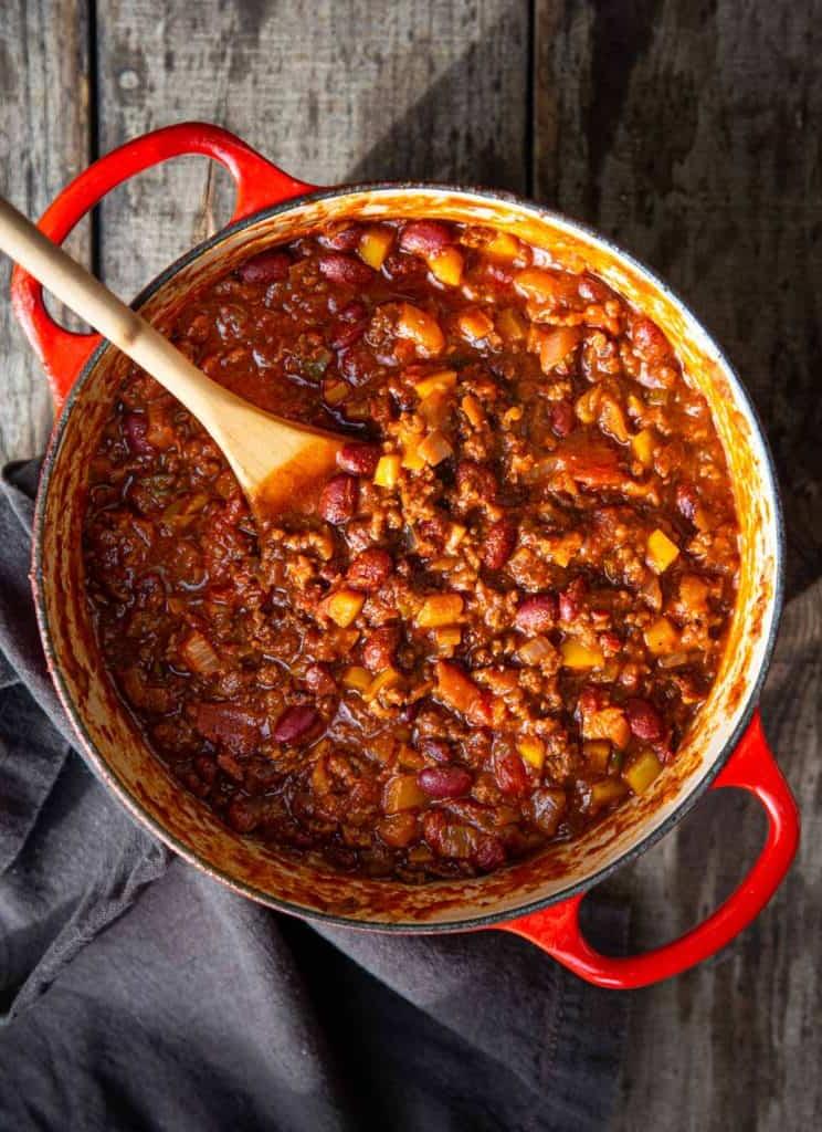 Ricetta del Chili con Carne Macinata e Peperoncini Chipotle 3 Una ciotola di chili di manzo guarnita con panna acida, avocado e jalapeño.