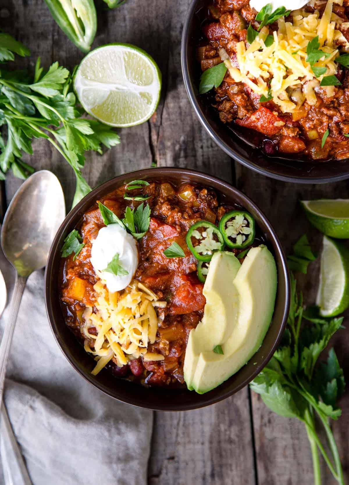 Ricetta del Chili con Carne Macinata e Peperoncini Chipotle 4 Due ciotole di chili di manzo guarnite con avocado, jalapeño, formaggio e panna acida.