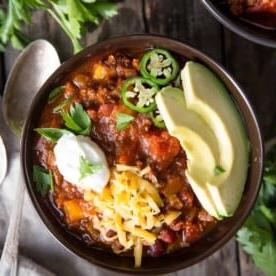 Ricetta del Chili con Carne Macinata e Peperoncini Chipotle 5 Una ciotola di chili di manzo guarnita con panna acida, avocado e jalapeño