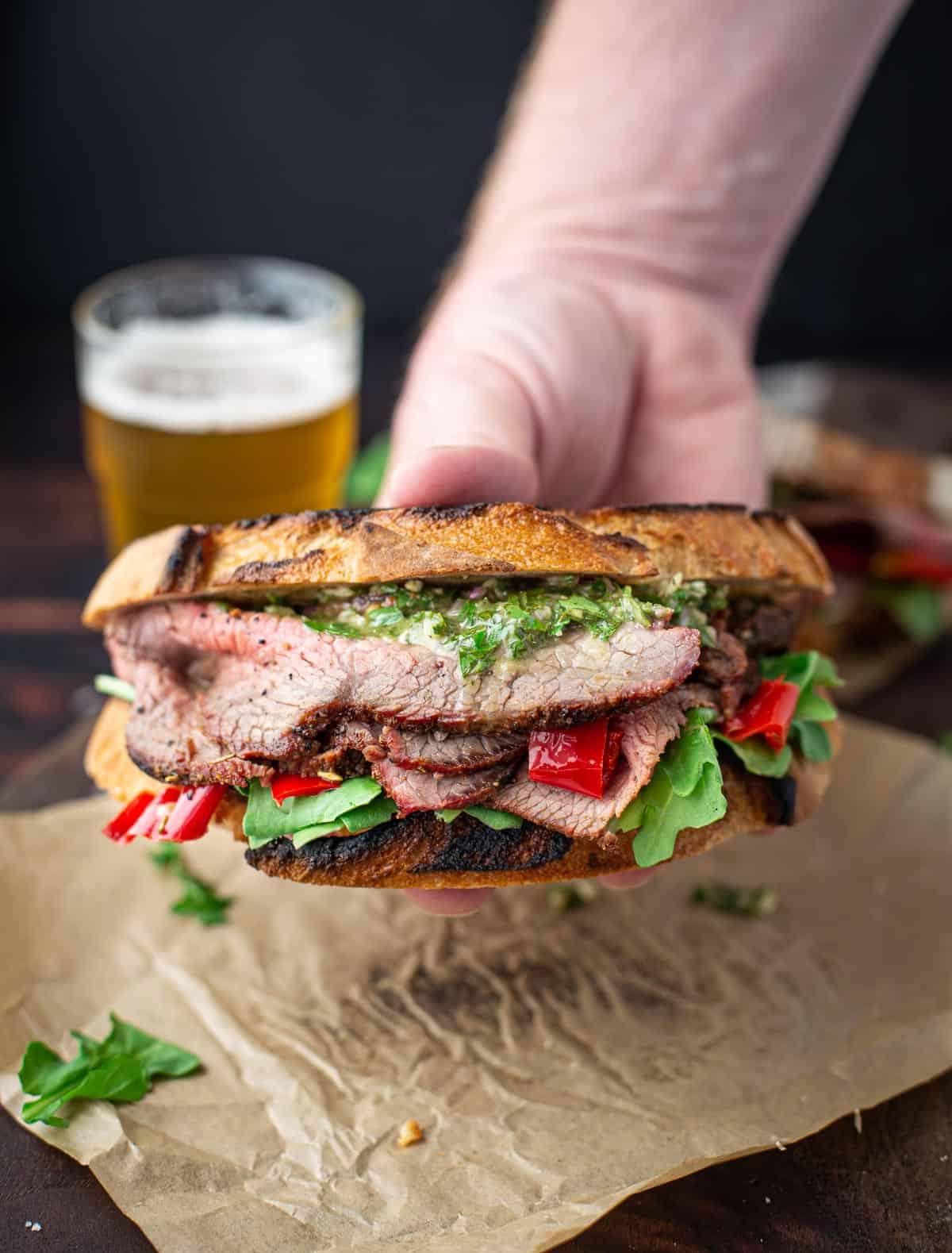 **Panino con Tri-Tip Affumicato e Salsa Chimichurri** 5 Tri Tip Sandwich in mano.