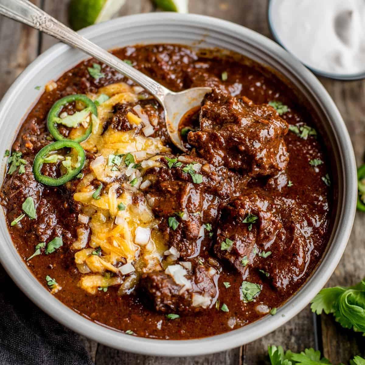 Chili alla texana in una ciotola con condimenti.