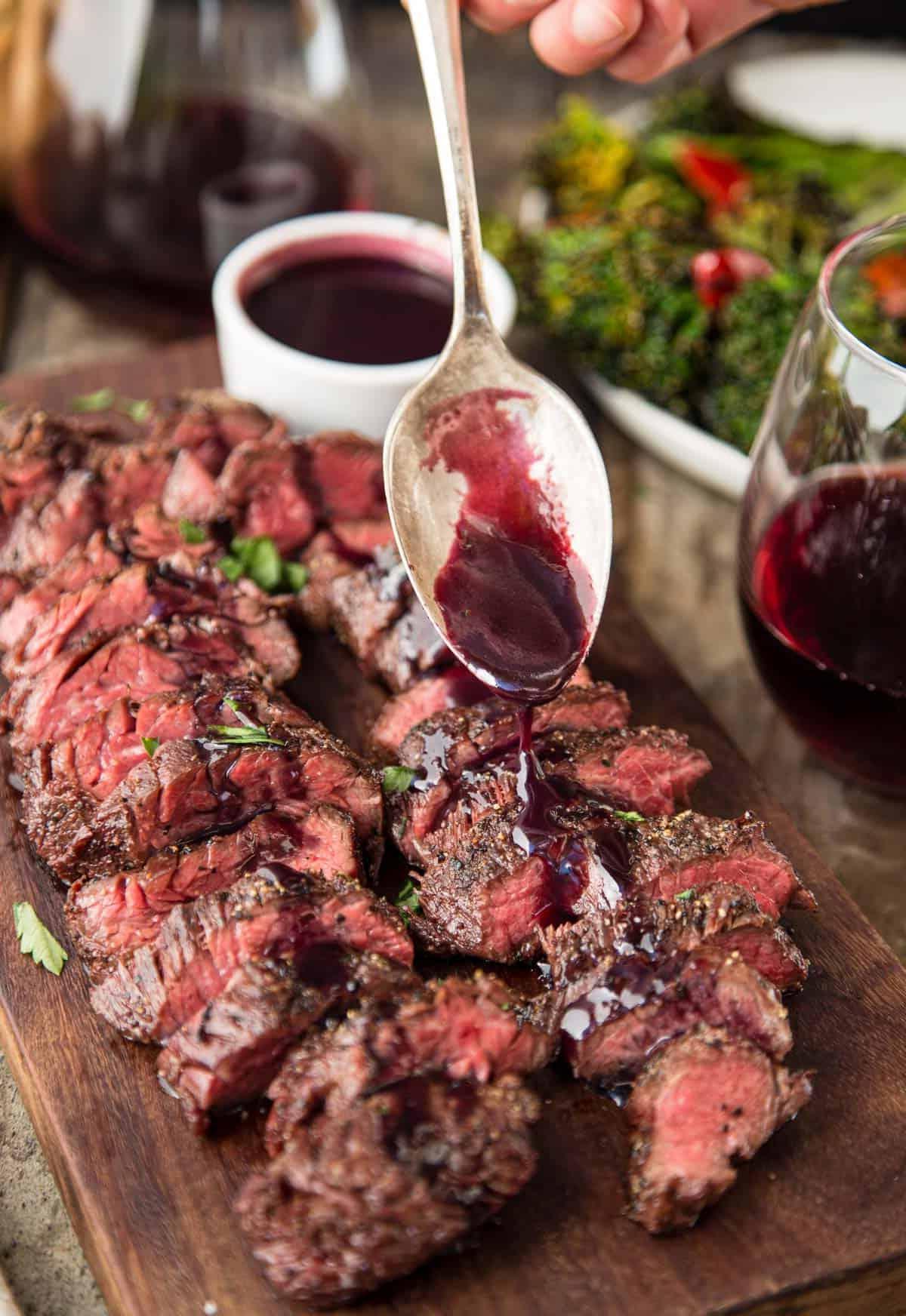 Diaframma di Manzo alla Griglia con Glassa al Pinot Nero e Marionberry 7 Fette di bistecca di diaframma alla griglia con salsa di riduzione al vino versata sopra
