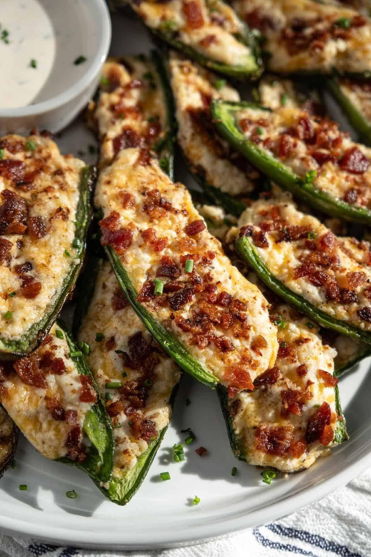 Come Preparare i Peperoncini Jalapeño Ripieni Grigliati 7 Un popper di jalapeño al formaggio guarnito con bacon croccante grigliato su un piatto da portata.
