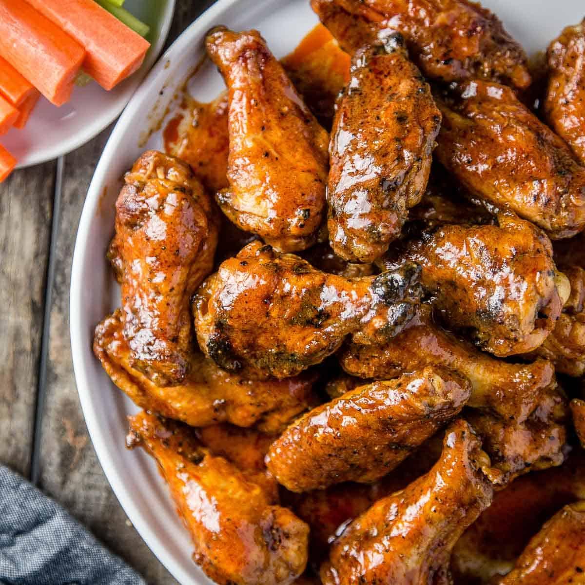 Le Migliori 15 Ricette di Pollo Affumicato 7 Ali di Pollo Buffalo Affumicate con pelle croccante su un piatto da portata