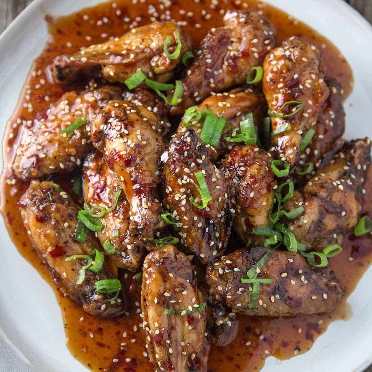 Le Migliori 15 Ricette di Pollo Affumicato 8 Ali Affumicate con Salsa al Peperoncino Thai Asiatica su un piatto