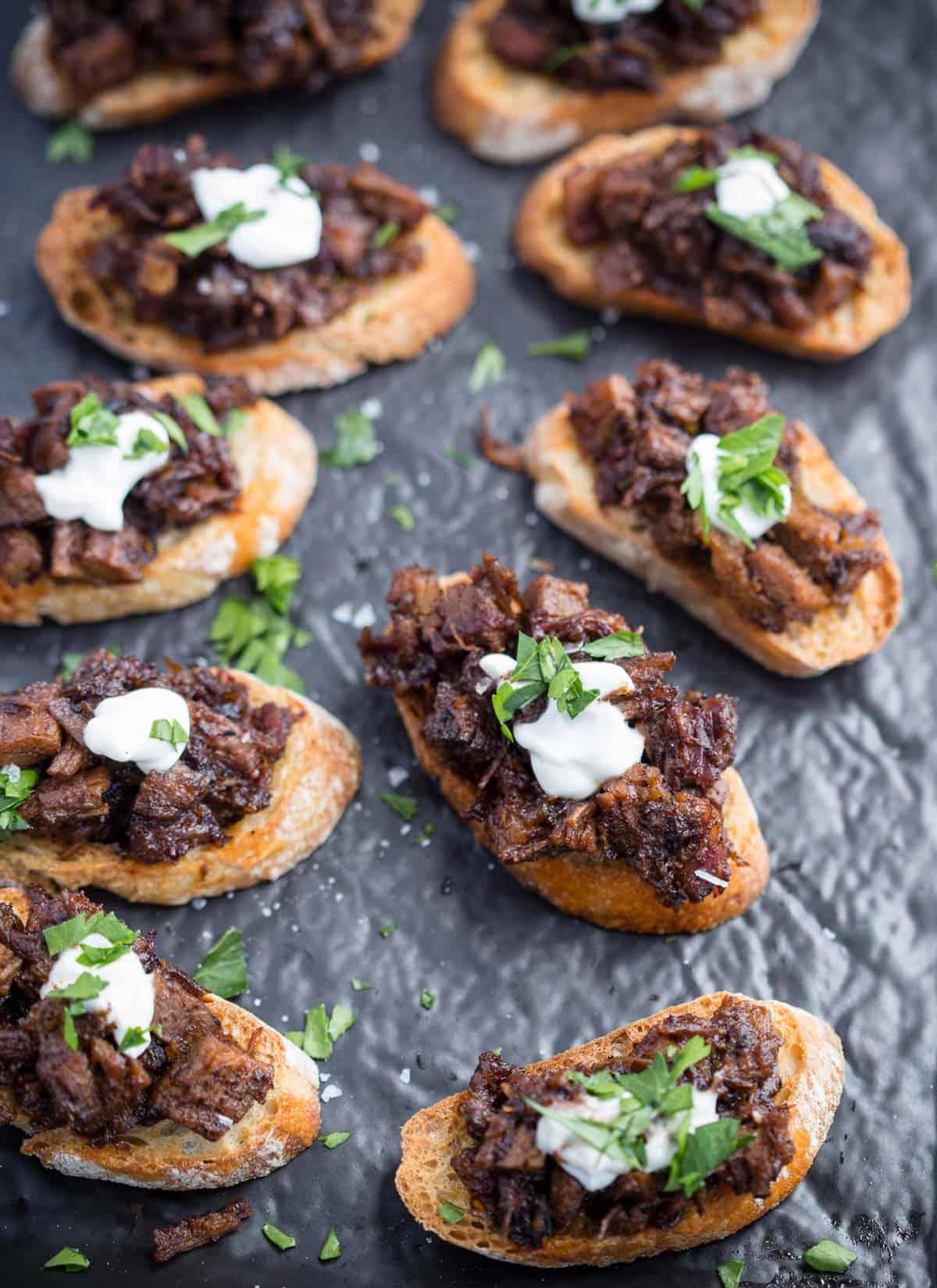 Le 10 migliori ricette con gli avanzi di punta di petto 9 Bruschetta di Brisket Crostini su un piatto.