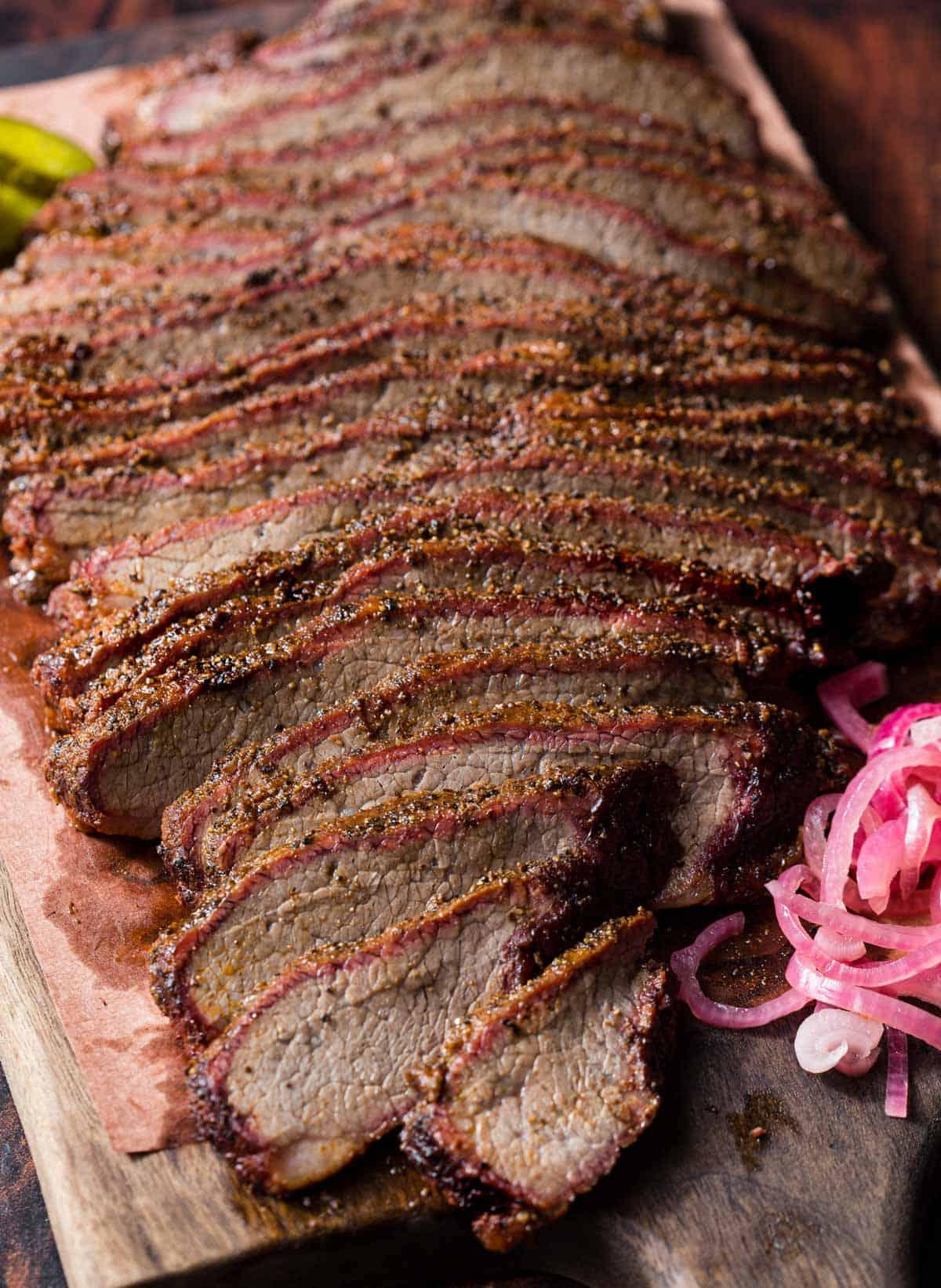 **Come affumicare il Brisket Flat** 10 Fette di brisket flat affumicato su un piatto con guarnizioni