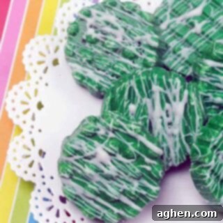 St. Patrick's Day Oreos 4 Candy-Dipped Green oreos with white chocolate drizzle on rainbow background.