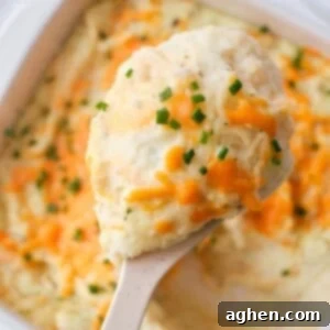 Garlic Herb Cheese Mash 2 A small bowl of cheesy garlic mashed potatoes garnished with herbs, ready for serving.