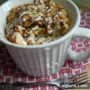 A small, golden-brown apple crisp in an individual serving dish, ready to be eaten.